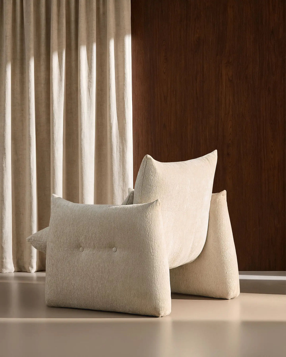 Rear side view of the cream Kumo Accent Chair highlighting its sculptural curved silhouette