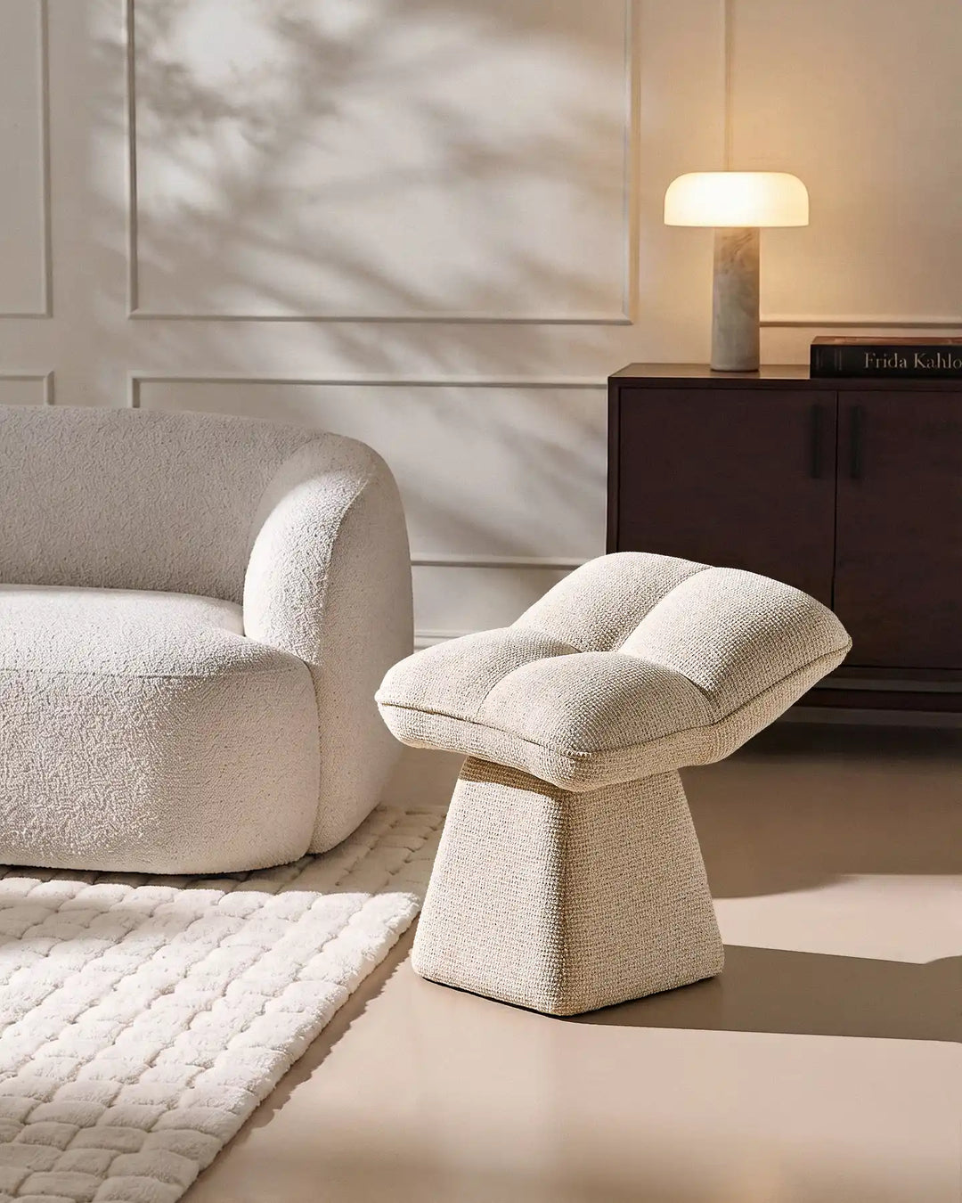 Liora beige swivel vanity stool paired with a curved upholstered chair and rug in a contemporary neutral living space