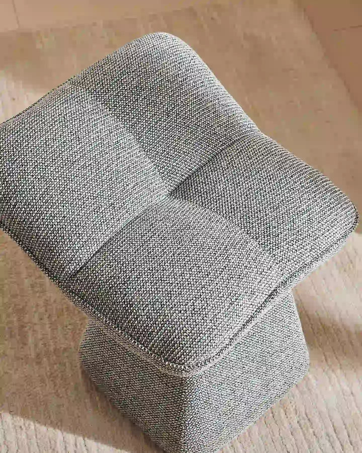 Close-up of the Liora grey vanity stool showing its plush segmented cushion design, soft upholstery and gently curved edges