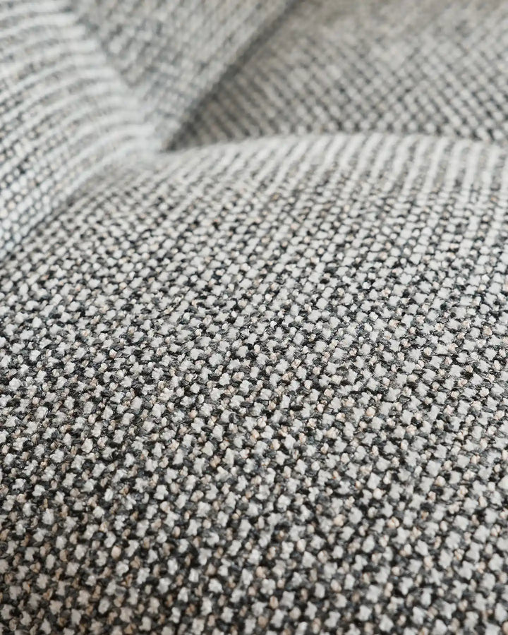 Close-up of the Liora beige swivel vanity stool upholstery showing the woven textured fabric and soft neutral beige tone