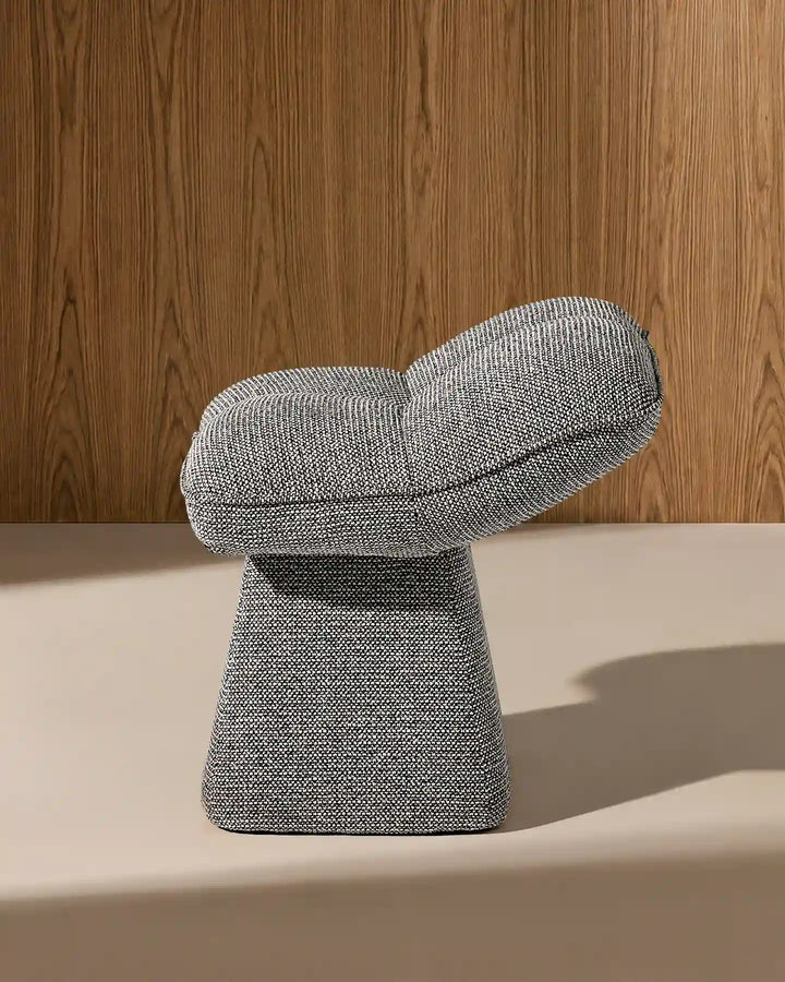 Side view of the Liora grey swivel vanity stool highlighting its curved seat profile and distinctive sculptural pedestal base