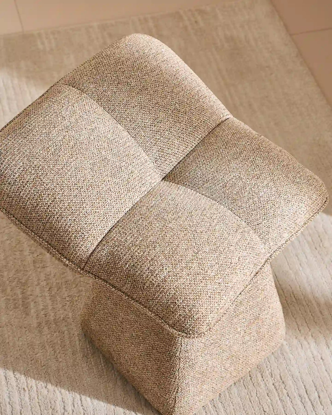 Close-up of the Liora khaki vanity stool showing its plush segmented cushion design, soft upholstery and gently curved edges