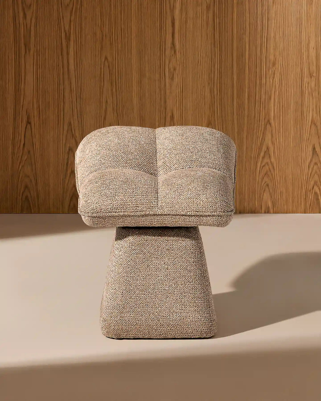 Front view of the Liora khaki swivel vanity stool showing its softly curved padded seat, textured upholstery and sculptural tapered base