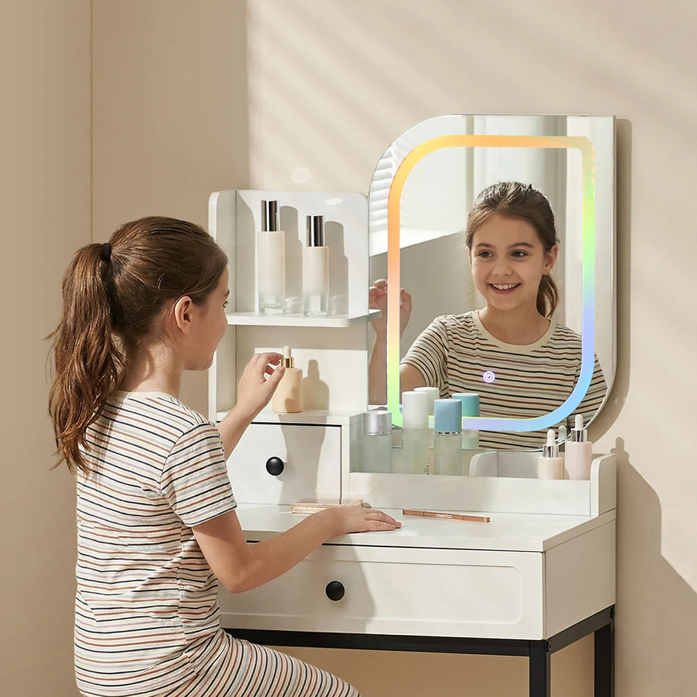 Little girl sitting at a RGB dressing table for girls, looking into the mirror
