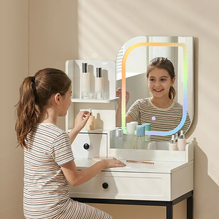 Little girl sitting at a RGB dressing table for girls, looking into the mirror