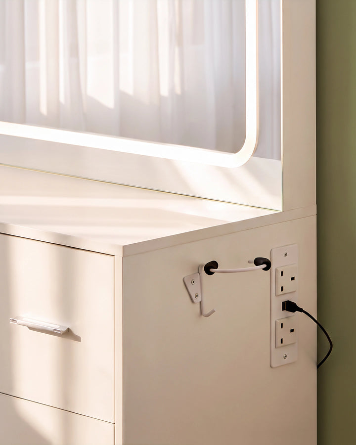 Close-up of the Luna white dressing table showing the built-in power sockets and dedicated hairdryer holder on the side, keeping hair styling tools organised and within easy reach.