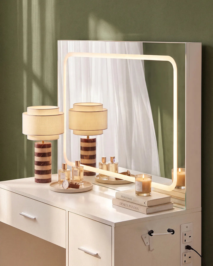 Close-up of the Luna dressing table's rectangular LED mirror with a soft ambient glow, paired with a white tabletop and decorative lamps.