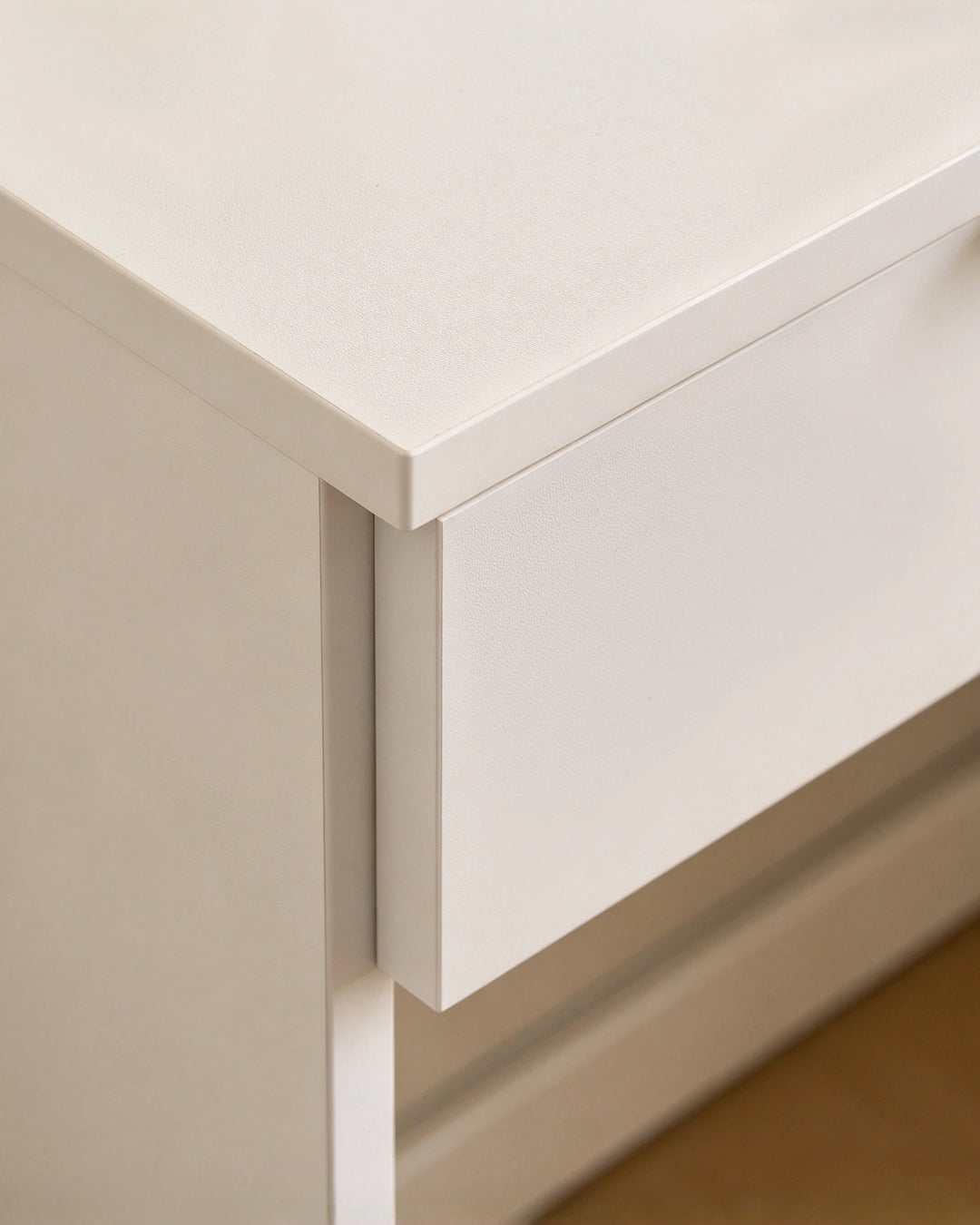 Close-up of the Lunea dressing table drawer front, highlighting the smooth white finish and minimalist handle-free design.