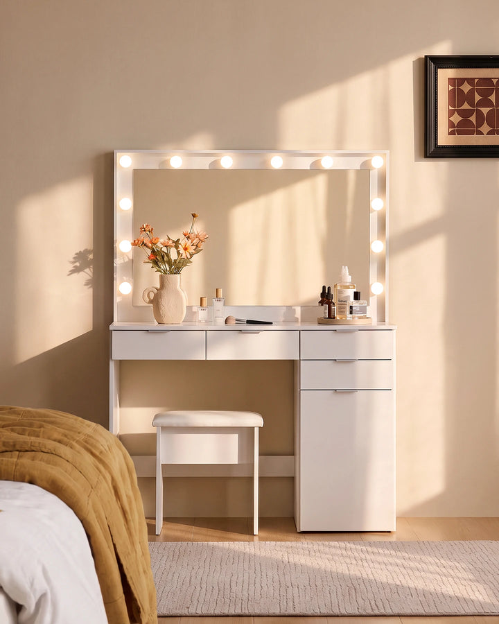 Lunea white dressing table set with four drawers, illuminated vanity mirror and matching stool in a warm neutral bedroom with natural sunlight.