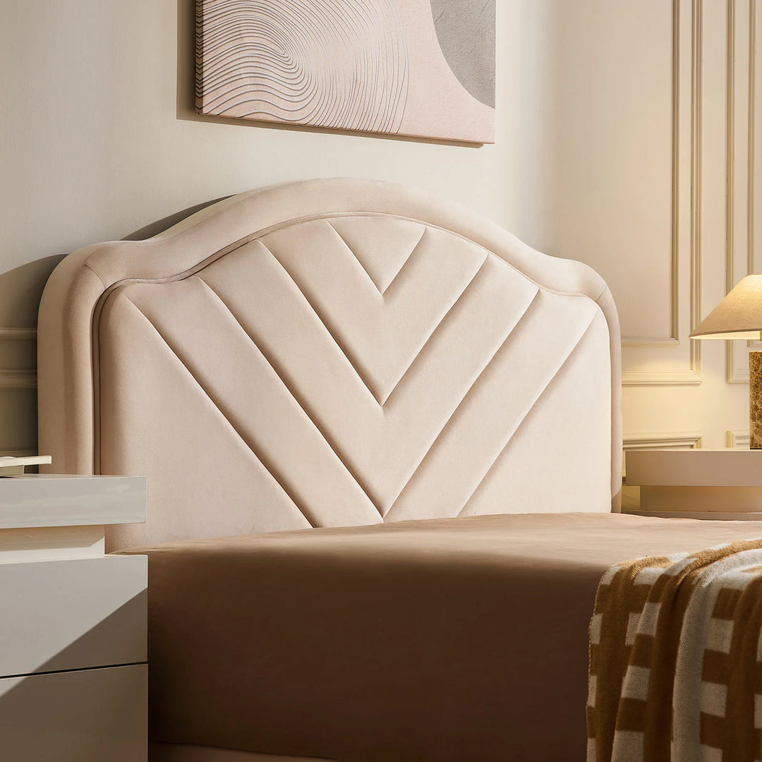 Close-up of velvet upholstered headboard on double bed frame with soft texture and V-stitch detail