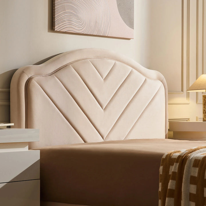Close-up of velvet upholstered headboard on double bed frame with soft texture and V-stitch detail