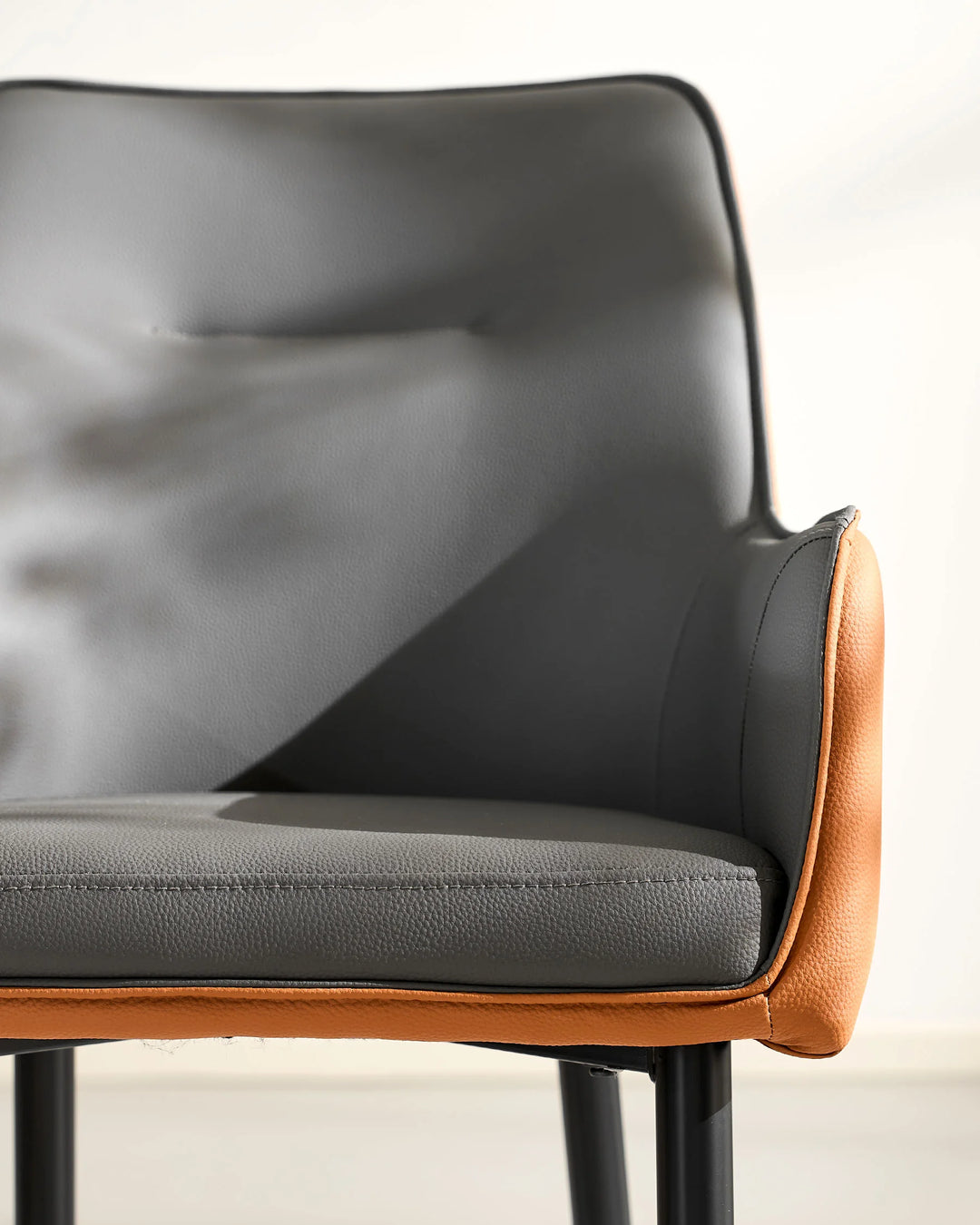 grey Maxine Dining Chair front view with curved armrest and upholstered seat detail