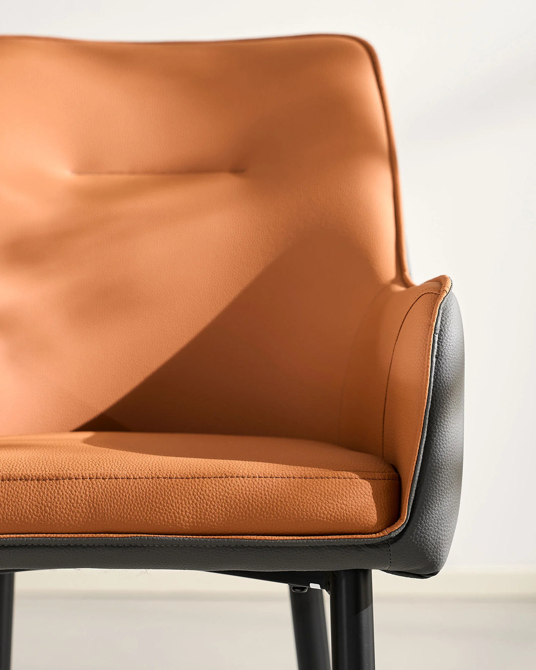 Brown Maxine Dining Chair front view with curved armrest and upholstered seat detail
