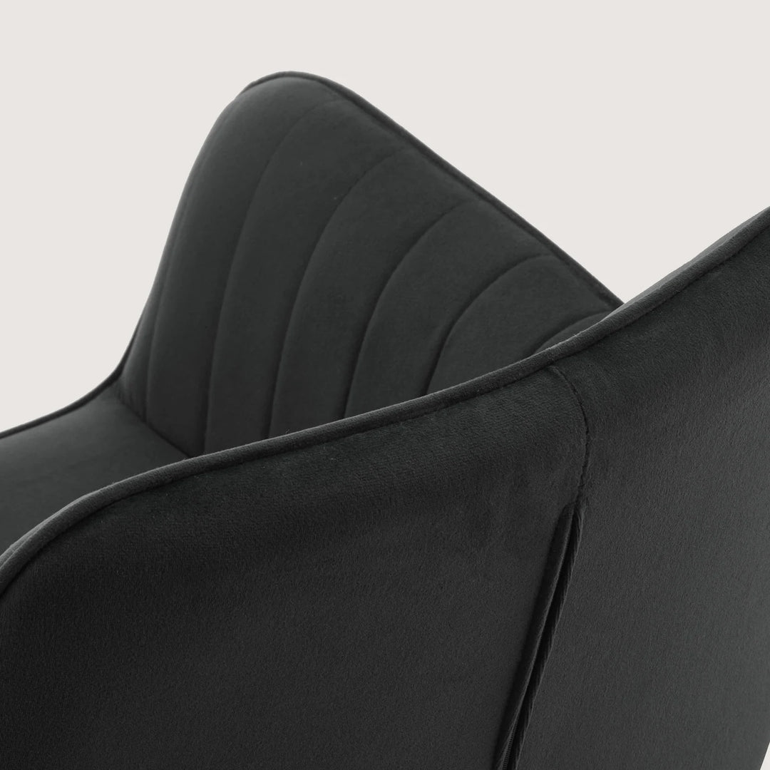 Close-up of Milo swivel chair showing soft velvet fabric and detailed stitching on armrests