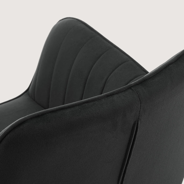 Close-up of Milo swivel chair showing soft velvet fabric and detailed stitching on armrests