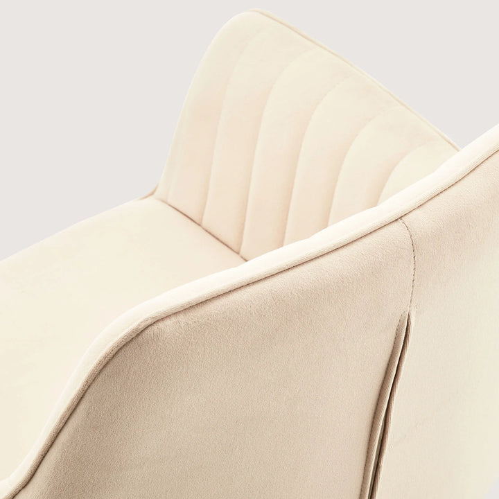 Close-up of Milo swivel chair showing soft velvet fabric and detailed stitching on armrests