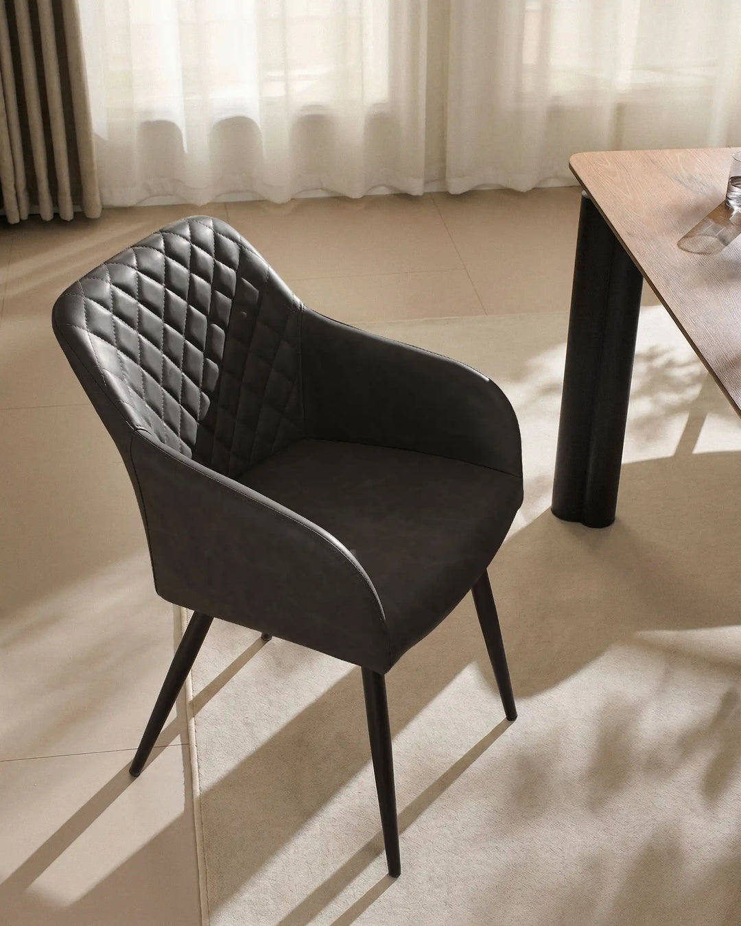 Single Moree dark grey Faux Leather Dining Chair Beside Dining Table in Warm Modern Interior