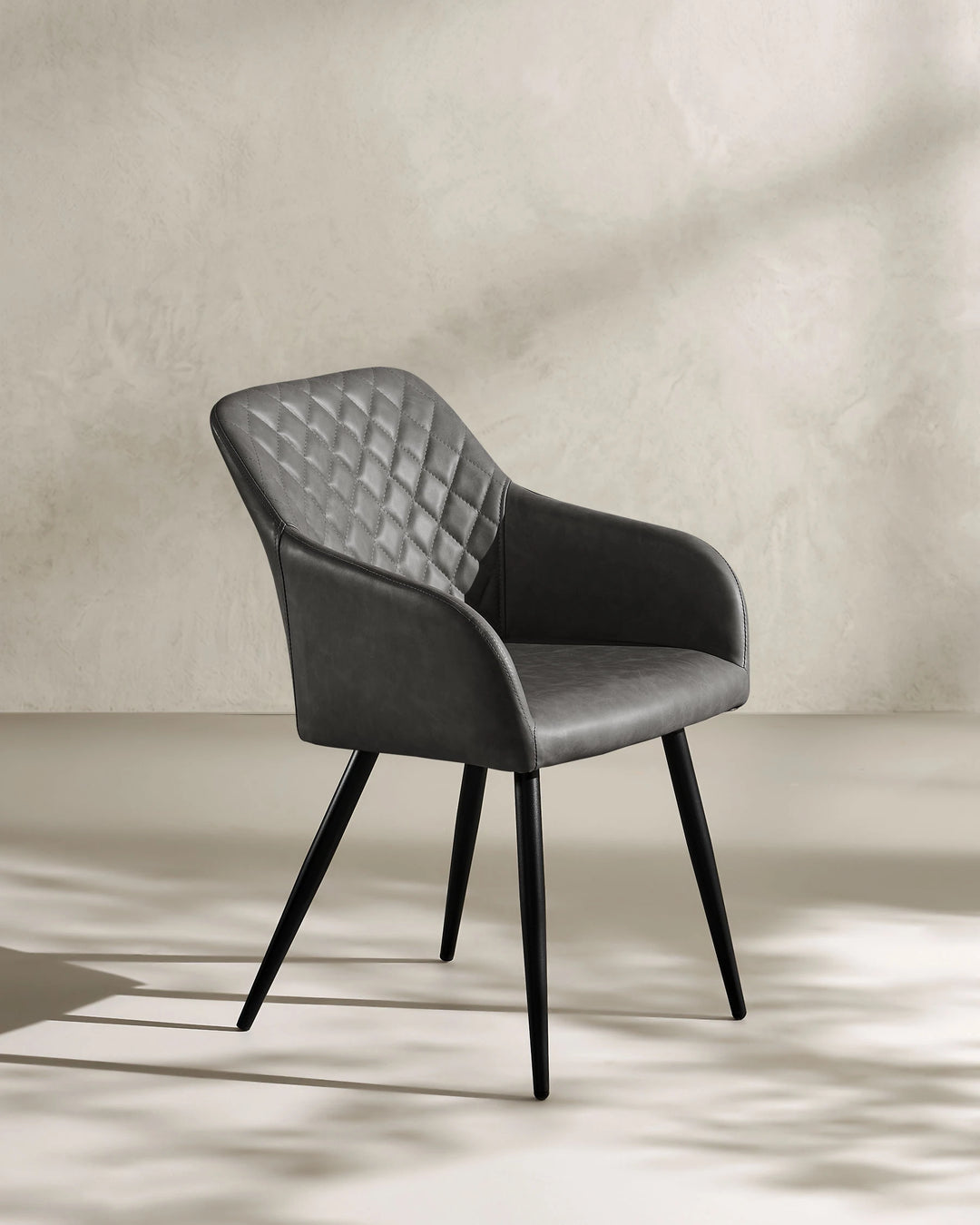 Moree dark grey Faux Leather Dining Chair Side 45 Degree View on White Background with Natural Shadow