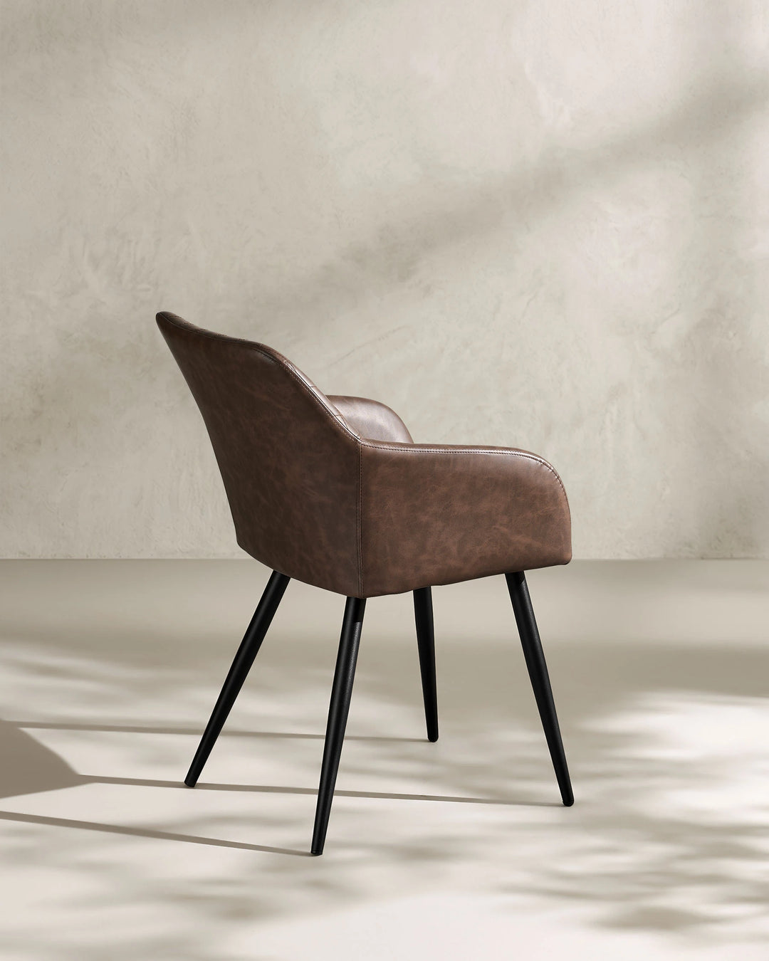 Moree Brown Faux Leather Dining Chair Side 135 Degree View on White Background with Natural Shadow