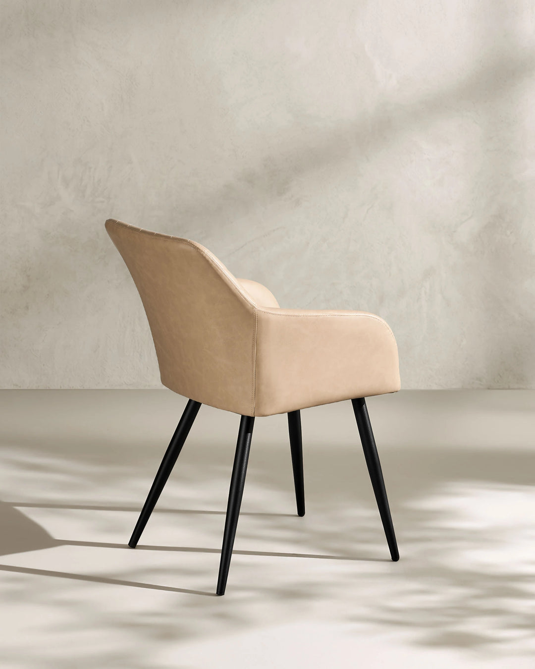 Moree beige Faux Leather Dining Chair Side 135 Degree View on White Background with Natural Shadow