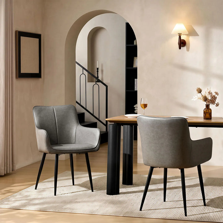 Two Muhsina grey faux leather dining chairs in a modern dining room setting