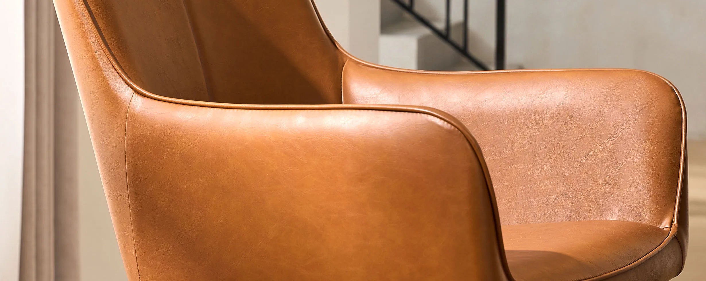 Side view armrest detail of Muhsina brown faux leather dining chair
