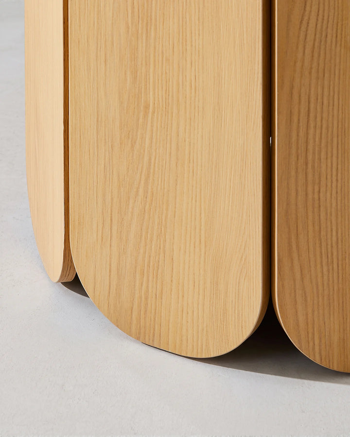 Close-up of the Nara dining table's rounded pedestal panels, showcasing the natural wood grain and curved edges