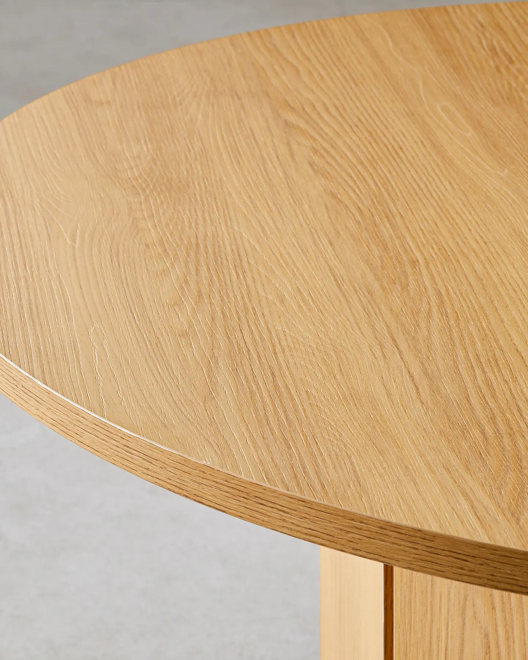 Close-up of the Nara dining table's natural oak-effect tabletop, highlighting the warm wood grain and smooth rounded edge