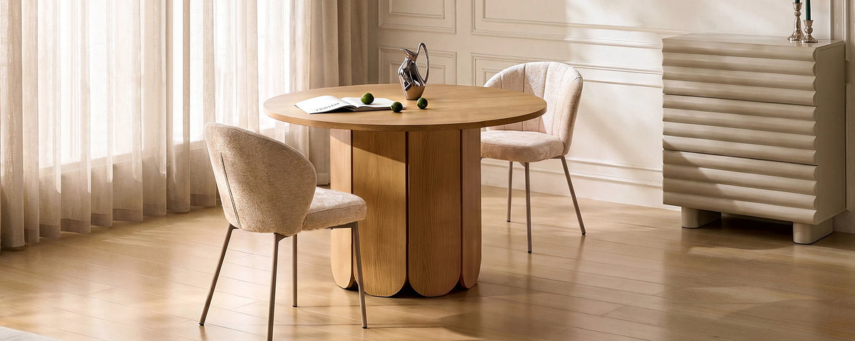 Nara round dining table styled in a modern neutral dining area with upholstered dining chairs, light curtains and a wooden sideboard