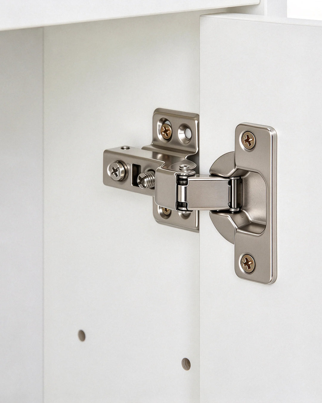 Close-up of the metal cabinet hinge on the white bathroom mirror cabinet, showing the door attachment and hinge mechanism.