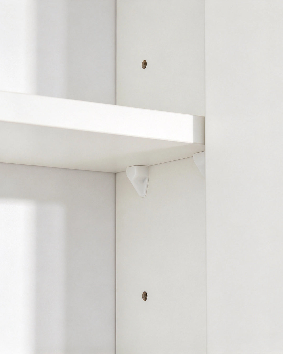Close-up of the adjustable shelf on a white bathroom mirror cabinet.