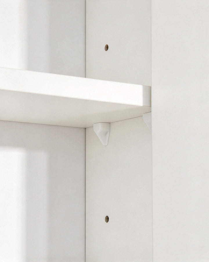 Close-up of the adjustable shelf on a white bathroom mirror cabinet.