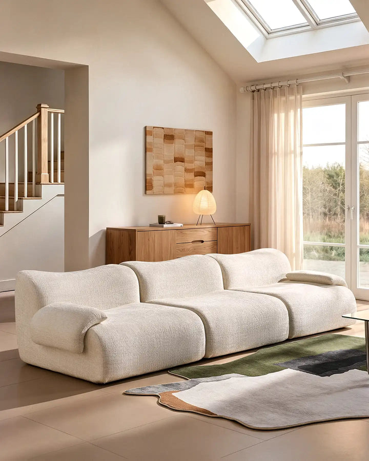Low-profile Nola sectional sofa in cream, showing its contemporary design and floor-standing silhouette.