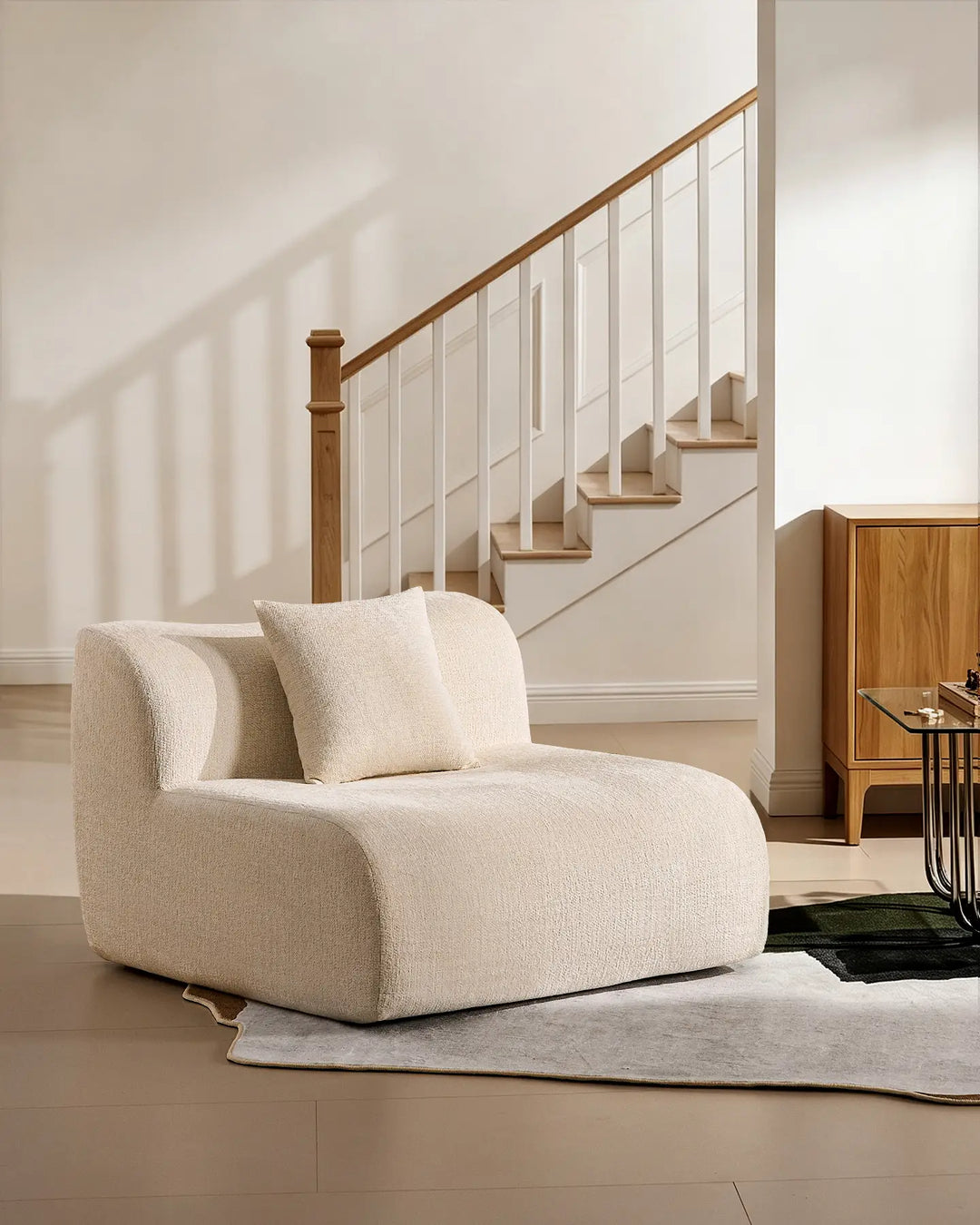 The Nola single modular section used as an accent armchair, featuring a matching cushion in cream fabric.