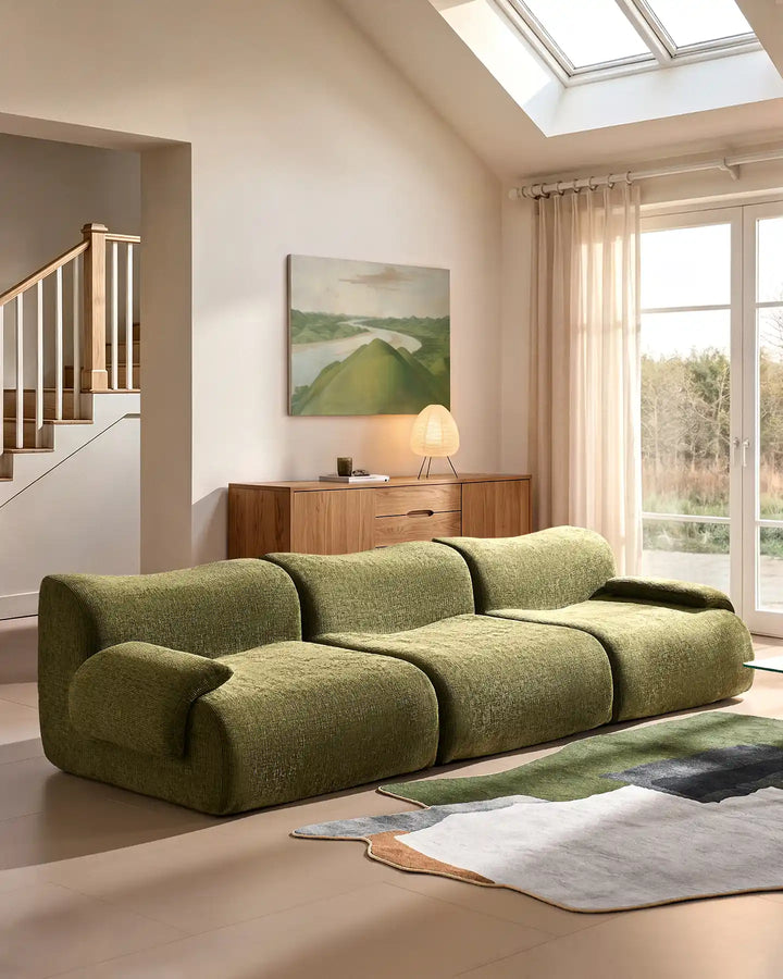 Low-profile Nola sectional sofa in green, showing its contemporary design and floor-standing silhouette.
