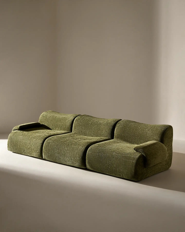 Angled studio shot of the Nola sectional, showing the deep-tufted style and modern curves.