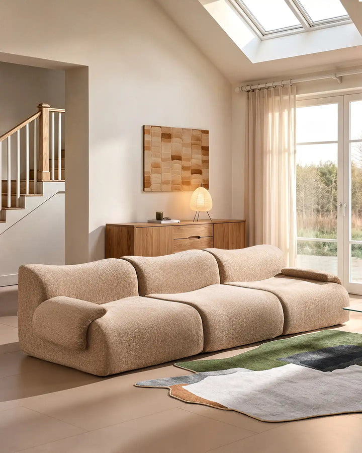 Side view of a low-profile 4-seater sectional sofa in a bright, contemporary lounge setting.