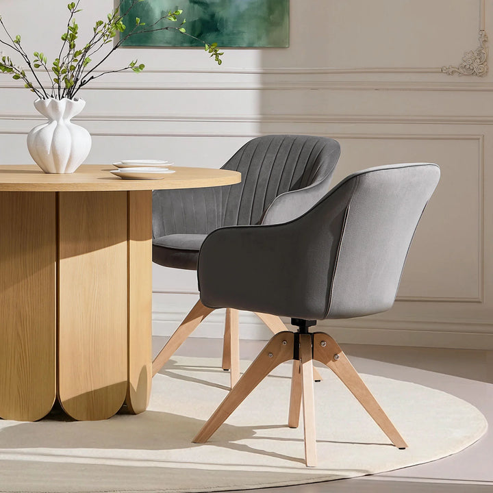 Pair of grey Oakley swivel dining chairs positioned at a dining table