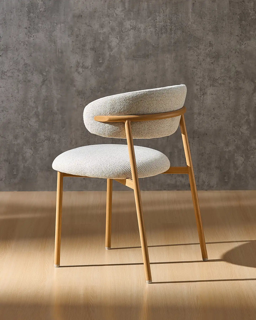 Rowan farmhouse dining chair angled view highlighting the curved silhouette and oak-effect frame