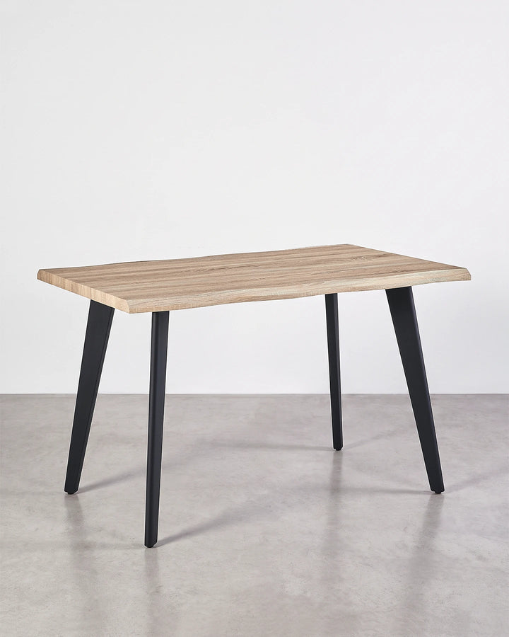 Angled view of the Seibold live edge dining table showing its organic tabletop shape and slim black legs