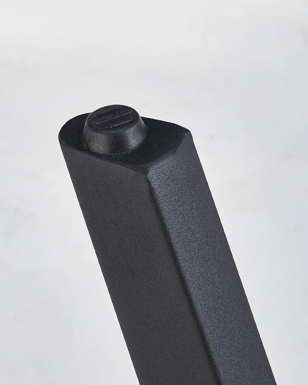 Close-up of the Seibold dining table leg showing the black foot pad and sturdy tapered leg design