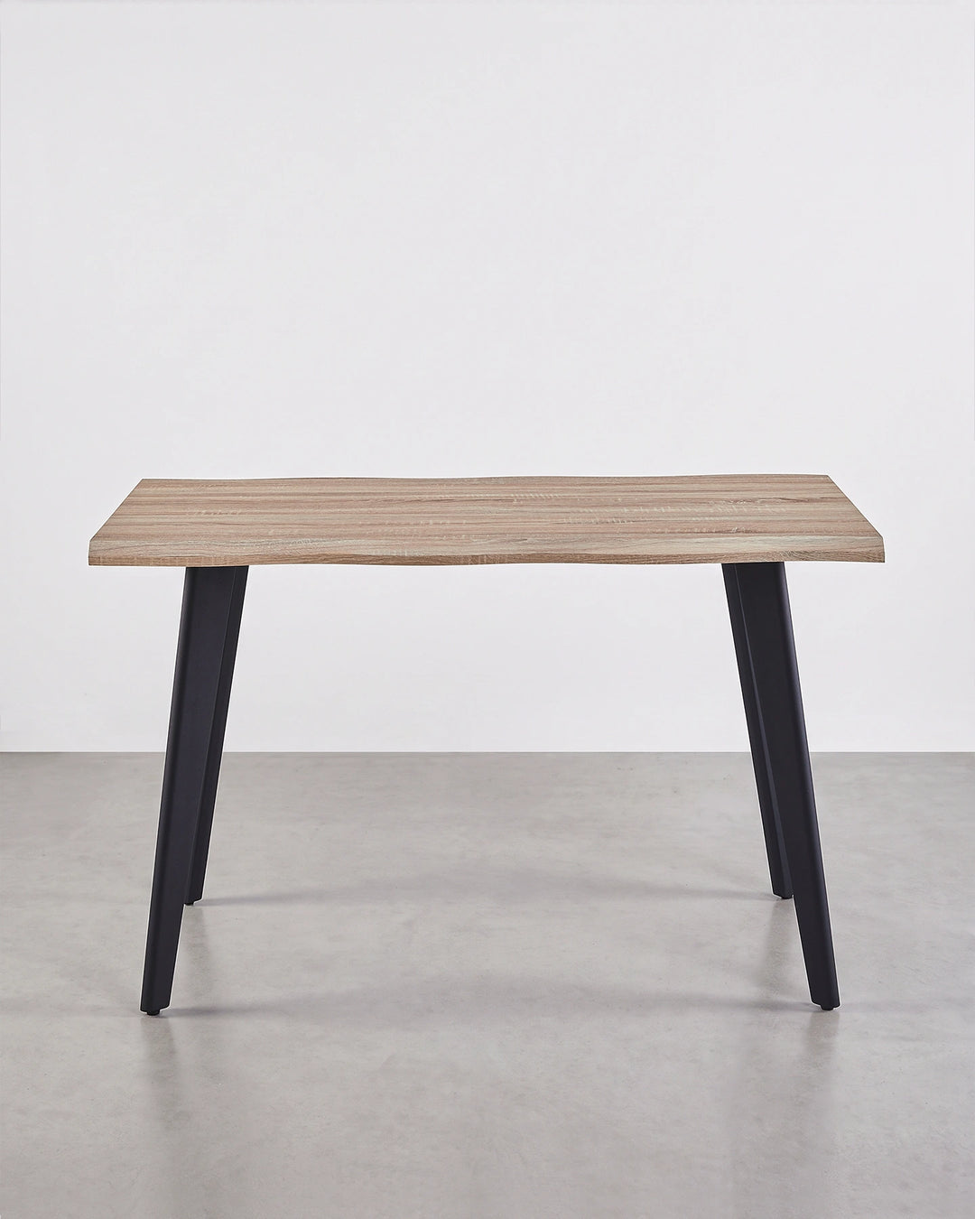 Front view of the Seibold live edge dining table with a natural wood-effect tabletop and four black tapered legs