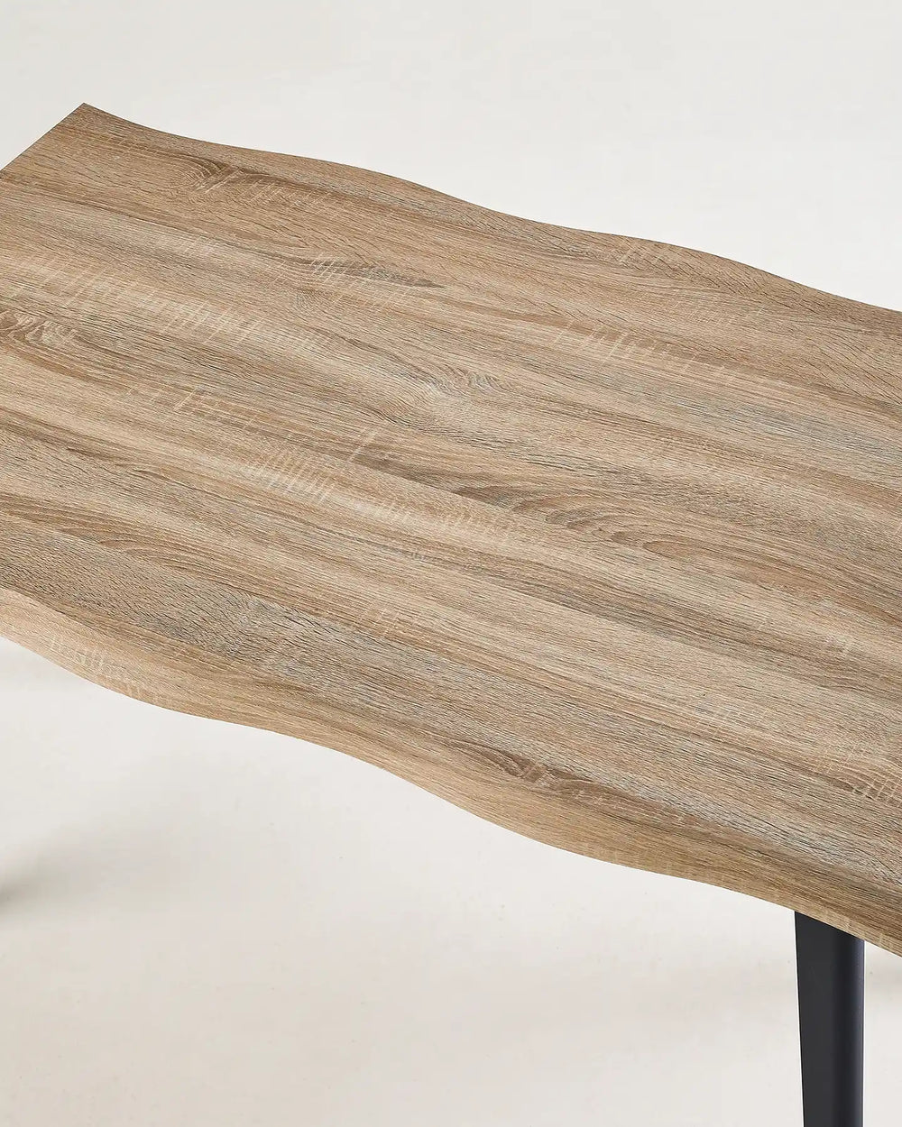 Close-up of the Seibold dining table showing the naturally irregular live edge and wood-effect grain pattern