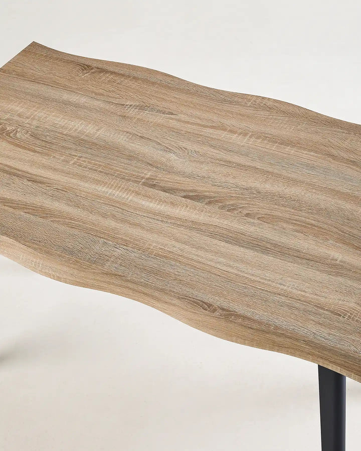 Close-up of the Seibold dining table showing the naturally irregular live edge and wood-effect grain pattern