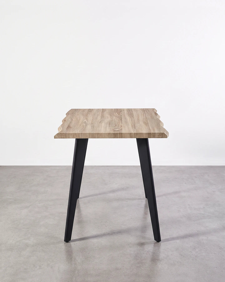Side view of the Seibold live edge dining table showing the slim tabletop profile and angled black legs