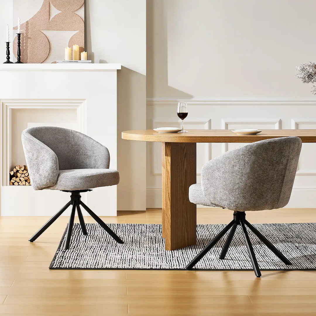 Two Cleo Grey Swivel Chairs in front of a dining table in a bright room