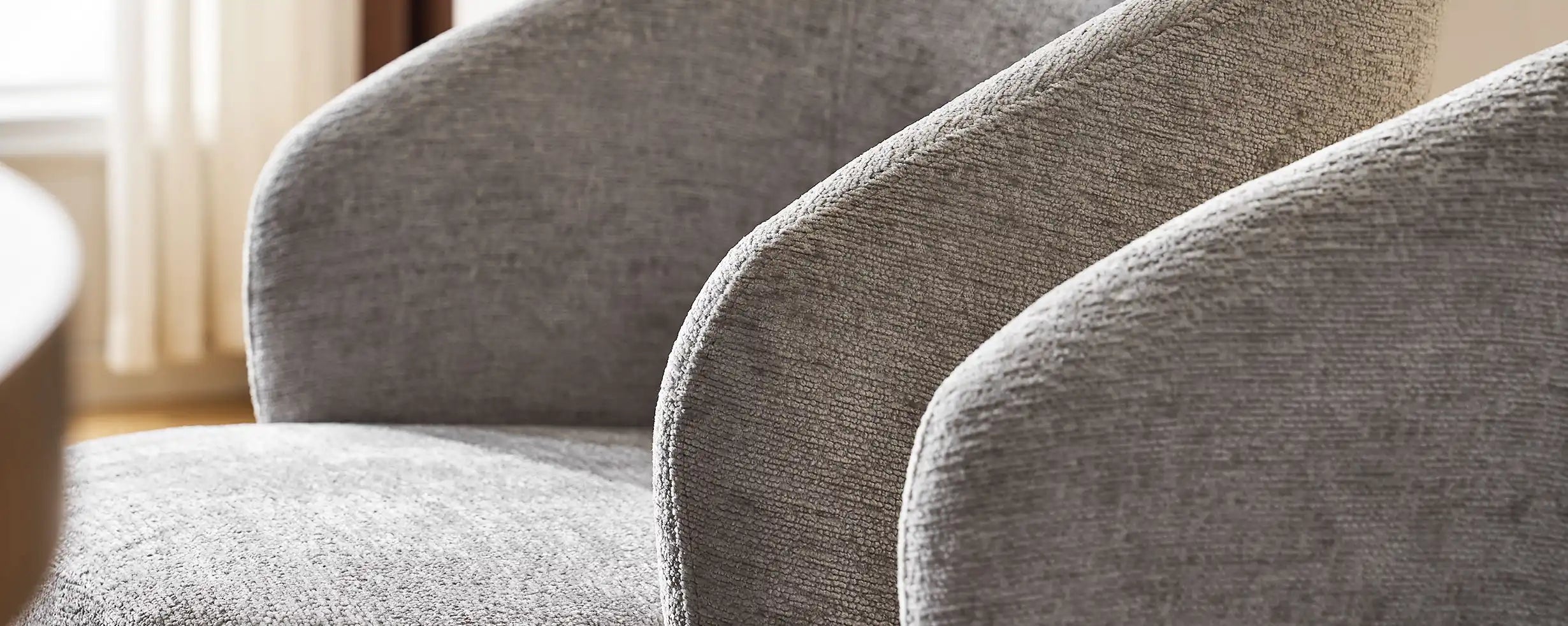 Curved armrest and soft grey chenille fabric of Cleo Grey Swivel Chair.