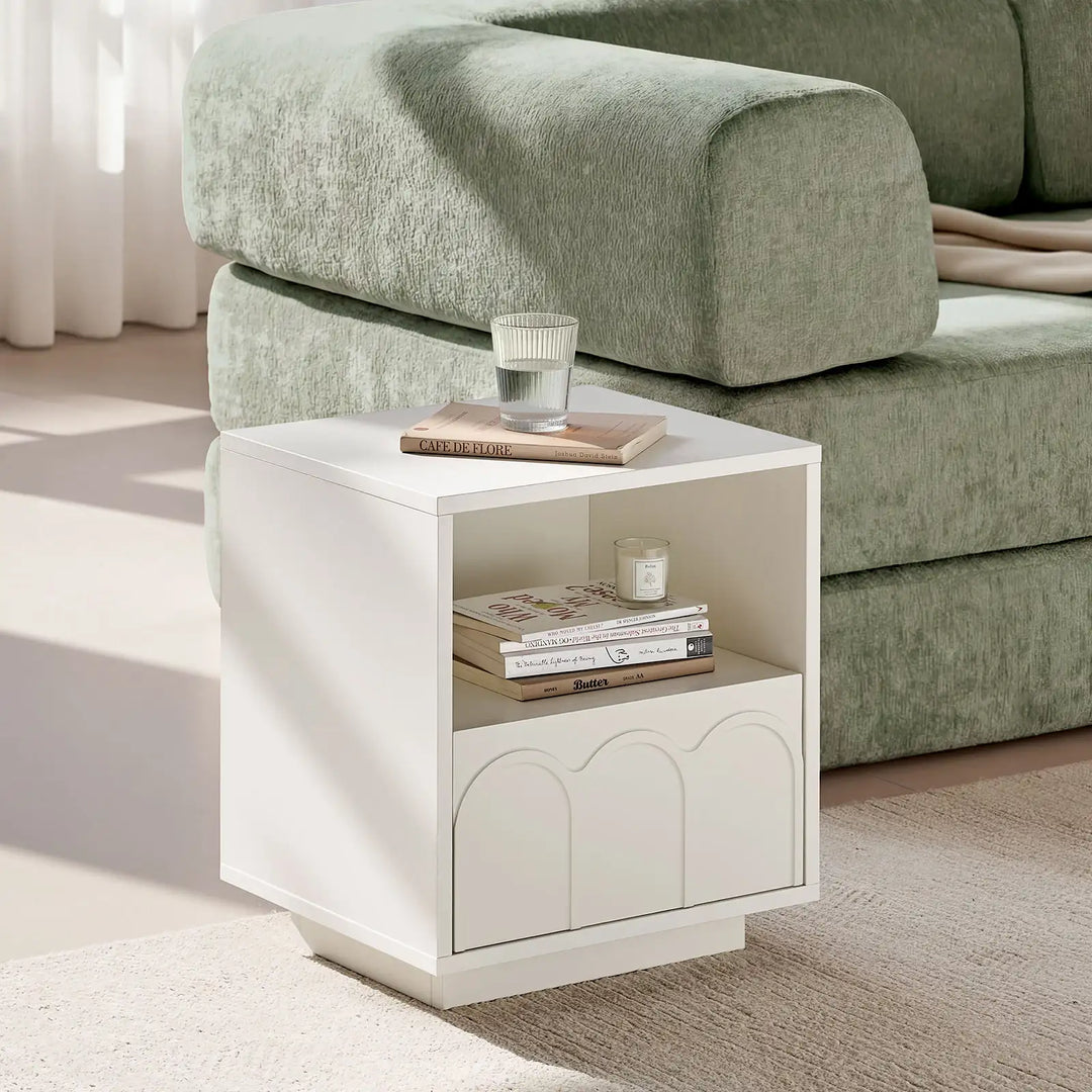 Doris Side Table beside a sofa with a glass of water on top, offering a comfortable and convenient spot for everyday living room relaxation.