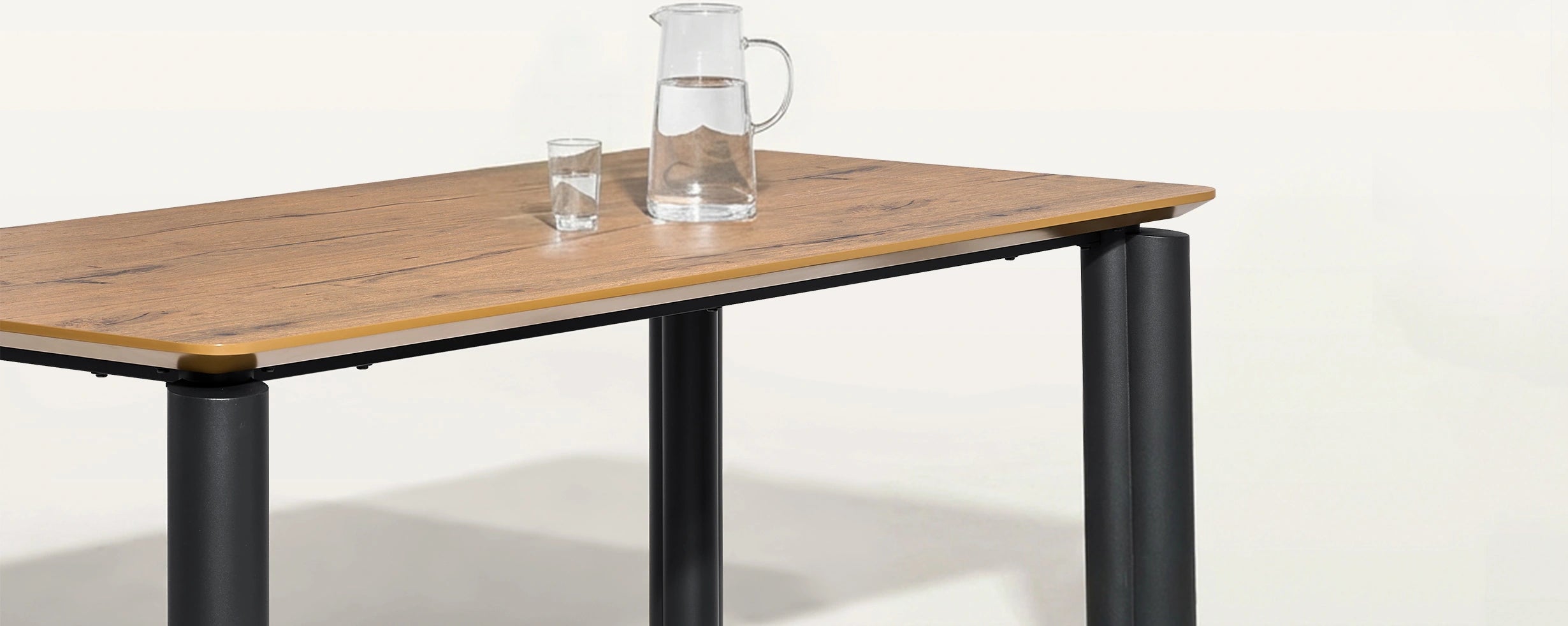 Close-up of Dundas walnut veneer dining table top and black metal legs in modern industrial style