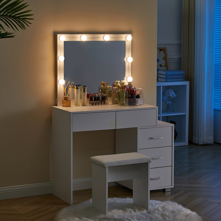 The side view of the Aurora Dressing Table with a mirror, 8 bright LED bulbs， 2 drawers, a 3-drawer cabinet, and a stool, in a dark bedroom.